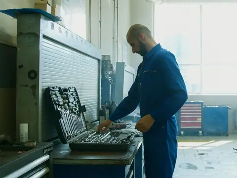 Technician sorting tools at a bench in a bright shop