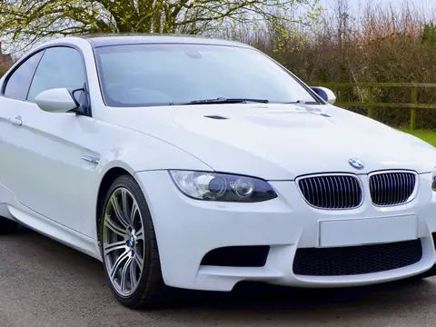 White coupe parked on a green lawn